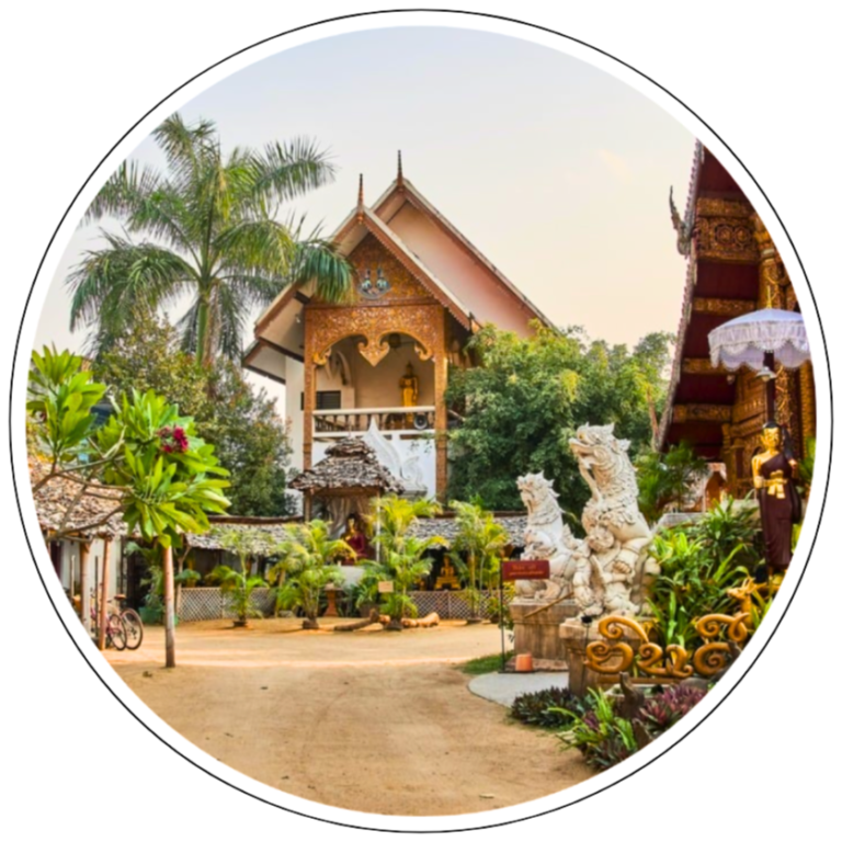 The picture is part of the travel blog 'The Essence of Traveling'. This travel blog features authentic and unique travel content such as compact travel guides and itineraries, travel tips and how-to guides, travel essays, and authentic perspectives about destinations from all around the world. The photo shows the temple gounds of a tempel in Chiang Mai, Thailand. There are three buildings decorated with ornaments and green vegetation such as a tall palm tree. In front of one of the temple buildings, there are two statues of white marble dragons. In the building in the background, there are two golden buddha statues.